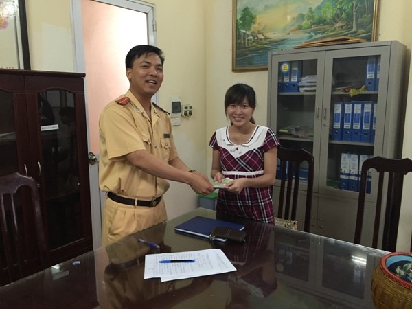 Chị Thu vui mừng, xúc động khi nhận lại số tài sản đánh rơi được Thượng úy Phạm Ngọc Thành-Đội phó Đội CSGT số 7 thay mặt BCH đơn vị trao trả