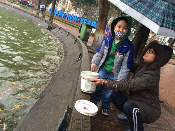 Người Hà Nội đội mưa lạnh thả cá chép tiễn ông Công, ông Táo ảnh 3