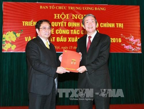Đồng chí Đinh Thế Huynh, Ủy viên Bộ Chính trị, Thường trực Ban Bí thư (bên phải) trao Quyết định của Bộ Chính trị cho đồng chí Phạm Minh Chính