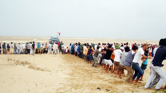 Hàng trăm người kéo tàu bị nạn vào bờ ảnh 1