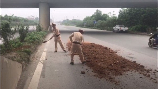 Cảnh sát giao thông Hà Nội quét dọn đất cát rơi trên đường ảnh 1