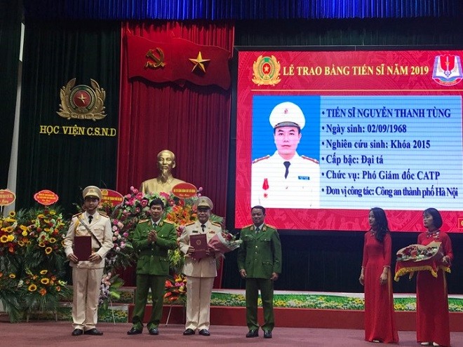 Đại diện Ban Giám đốc Học viện Cảnh sát nhân dân trao bằng Tiến sỹ cho Đại tá Nguyễn Thanh Tùng - Phó Giám đốc Công an thành phố Hà Nội