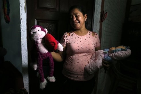 Bà nội của bé Valeria cầm trên tay những món đồ chơi yêu thích của cô bé xấu số