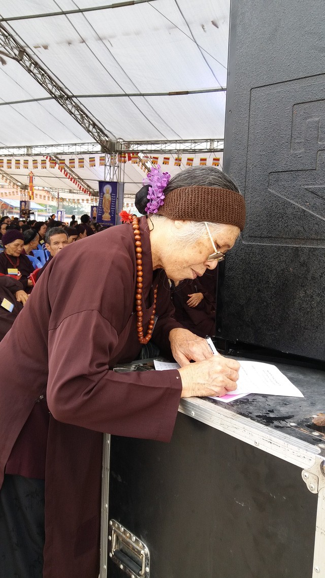 Cụ Nguyễn Thị Ty, 75 tuổi, ở TP Uông Bí đang ghi tên người thân bị TNGT vào danh sách để cầu siêu chân linh