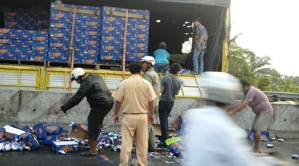 Người dân giúp tài xế thu dọn hàng trăm thùng bia đổ xuống đường ảnh 1